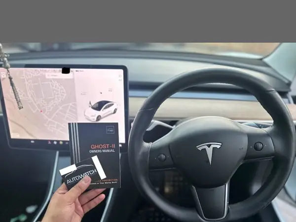 Ghost-II owners manual held inside a freshly fitted Tesla Model 3